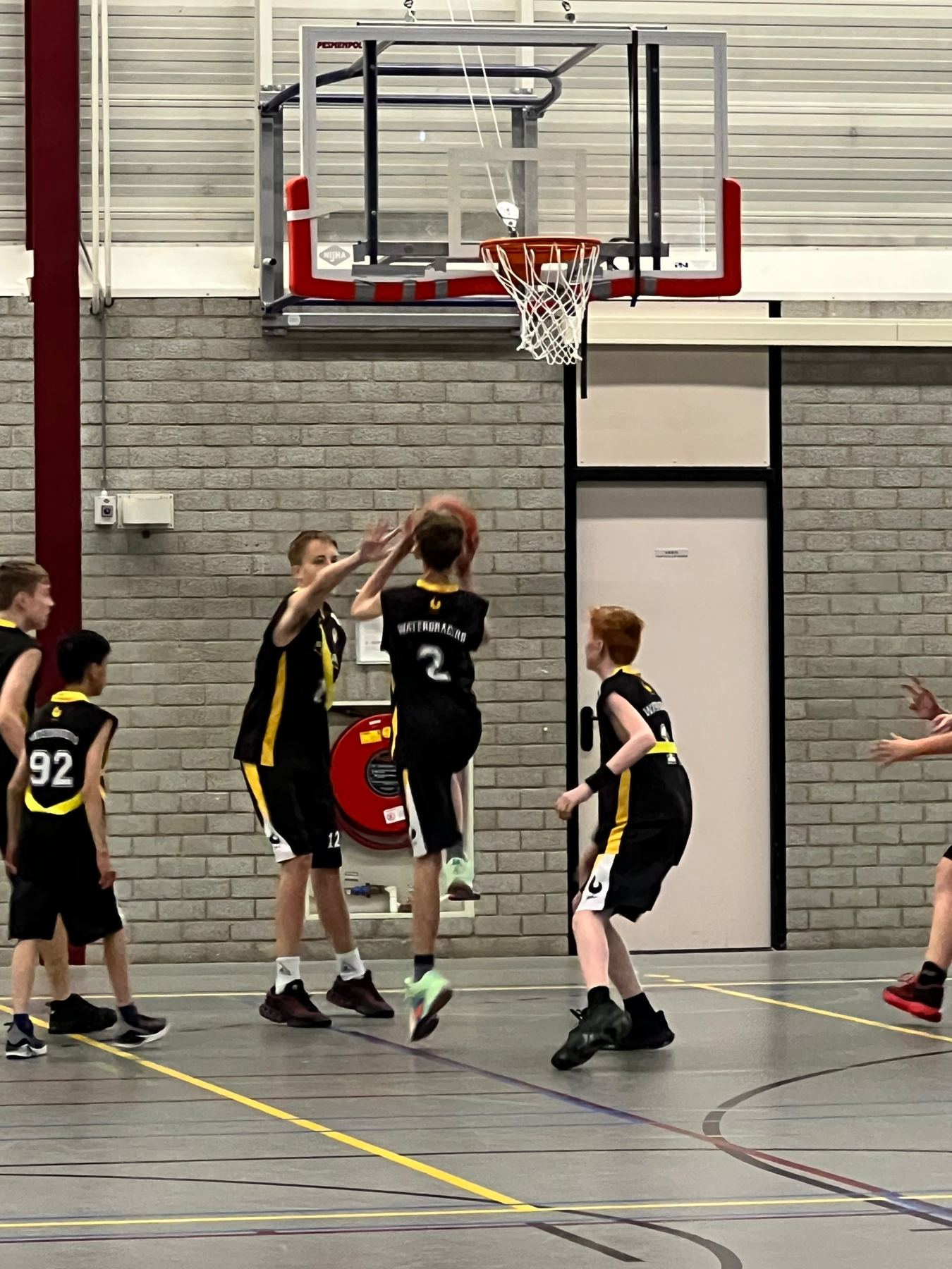 Jongens van de Waterdragers verdedigen onder de basket
